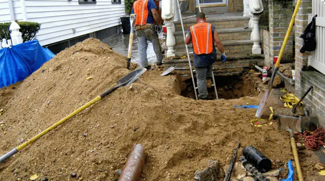 Contractors performing foundation protection and exterior drainage excavation near residential home steps in Charlotte, NC